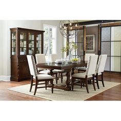 a dinning room table with chairs and a china cabinet in the backround