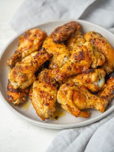 a white plate topped with chicken wings on top of a table