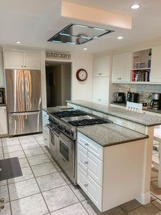 a kitchen with an oven, stove and refrigerator in it's center island next to a dining room table