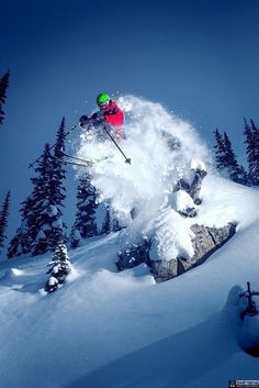 a person jumping in the air on skis while skiing down a snowy mountain side