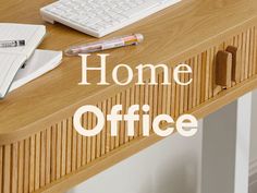 a desk with a keyboard, pen and notebook on it that says'home office '