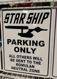 a sign that is on the side of a shelf in a store saying, star ship parking only all others will be sent to the roman neutral zone