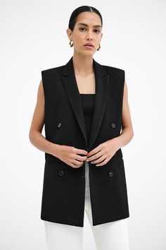 Our Selena Vest is an investment piece that promises a high return in style. Inspired by our Norah Blazer, Selena’s relaxed, sleeveless fit from lightweight European polyviscose features a lapel collar, double welt pockets, and a slit at the back. She's fully lined with padded shoulders and double-breasted fastening for structure and versatility, bringing a feminine touch to the enduring charm of a menswear-inspired classic. | Astrid, in black, is 5'9" (175 cm) tall, wearing size XS. Yada, in of Black Vest Outfit Women, Black Blazer Vest Outfit, Vest Blazer Outfits For Women, Black Sleeveless Blazer Outfit, Vest Blazer Outfit, Blazer Vest Outfit, Black Sleeveless Blazer, Sleeveless Blazer Outfit, Black Vest Outfit