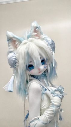 a doll with white hair and blue eyes is dressed in an unusual outfit, holding a bag