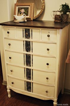 a white dresser with drawers and a mirror on top