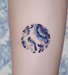 a blue and white flower tattoo on the right side of a woman's leg