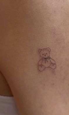 a small tattoo of a teddy bear on the back of a woman's thigh