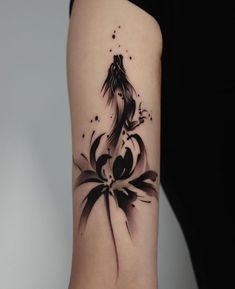 a woman's arm with a black and white tattoo on it