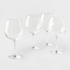 four empty wine glasses sitting next to each other