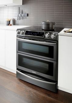 a kitchen with an oven, stove and counter tops in black stainless steel finish is shown