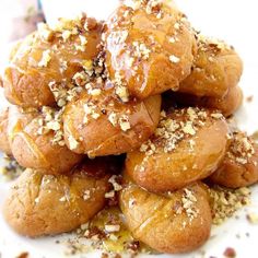 a pile of doughnuts sitting on top of a white plate covered in sesame seeds