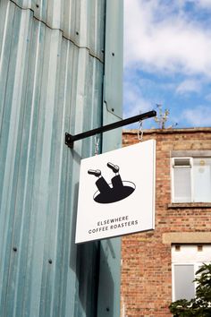 a sign hanging from the side of a building that says coffee roasters on it