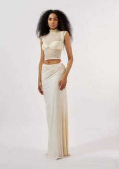 Emanate elegance and contemporary allure with this ensemble comprising a malai lycra draped skirt featuring intricately crafted knot detailing at the waist. Paired harmoniously with a modal satin pleated bralette, exuding sophistication and a touch of luxury. Complete the look with a mesh high neck top, adding a modern twist and ensuring you stand out with refined confidence at any upscale event or stylish gathering. Elegant Ruched Draped Skirt For Night Out, Elegant Wedding Draped Skirt, Pre-draped Long Skirt For Party, Elegant Ruched Draped Skirt For Evening, Elegant Fitted Draped Gathered Skirt, Evening Draped Skirt With Ruched Detail, Evening Flowy Ruched Draped Skirt, Flowy Ruched Draped Skirt For Evening, Fitted Draped Satin Skirt