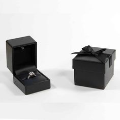 an open black box with a ring in it and a bow tie around the top