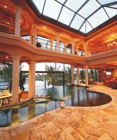 an indoor swimming pool in the middle of a large room with high ceilings and glass windows