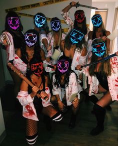 a group of people in costumes with neon masks on their faces and holding onto swords