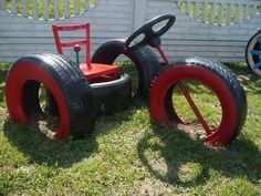 two children's toy cars made out of tires and wheels sitting in the grass