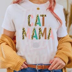 a woman with pink hair wearing a t - shirt that says cat mama