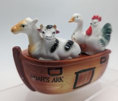 there are three small figurines in the shape of farm animals on top of a boat