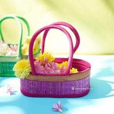 a basket with flowers in it sitting on a table next to two baskets filled with flowers