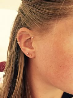 a close up of a person with ear piercings on their ears and one in the background