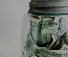 a jar filled with money sitting on top of a table