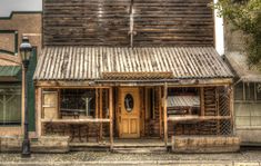 an old wooden building sitting on the side of a road