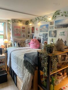 a bed room with a neatly made bed and lots of clutter on the walls