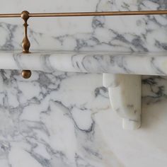 a white marble wall with brass handles on it