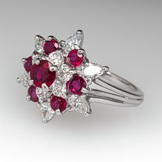 This beautiful ring is centered with a four-prong set, round cut ruby, surrounded by six (6) prong set, round brilliant cut diamonds. The top of the ring is accented with six (6) smaller, round mixed cut rubies and six (6) pear brilliant cut diamonds in prong settings. The ring measures 16.4mm at the top, rises 10.6mm above the finger, tapering to 1.4mm wide and 1.0mm thick at the base of the shank. This ring is currently a size 4.5. Formal Ruby Ring With Diamond Accents In Cluster Shape, Red Cluster Ring With Brilliant Cut, Red Cluster Ring With Brilliant Round Cut, Formal Cluster Ruby Ring With Diamond Accents, Classic Red Ruby Ring With Single Cut Diamonds, Classic Red Cluster Diamond Ring, Classic Red Diamond Ring With Single Cut Diamonds, Ruby Ring With Diamond Cluster And Brilliant Cut, Red Cluster Diamond Ring With Brilliant Cut