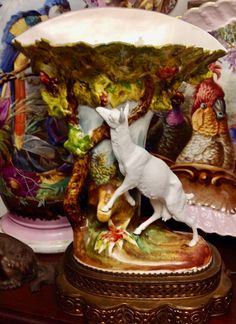 a white deer figurine on top of a table next to other decorative items