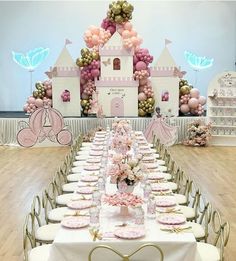 a table set up for a princess party with pink and gold balloons in the background