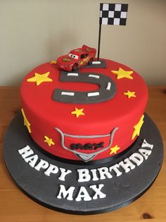 a birthday cake with a car on top and the number six on it's side