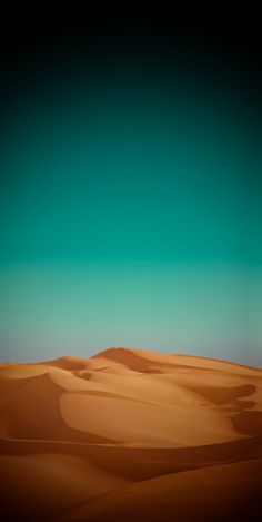 the desert is full of sand dunes and blue sky in the distance, with no clouds