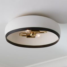 a ceiling light with three lights on it in a white and black color scheme, hanging from the ceiling