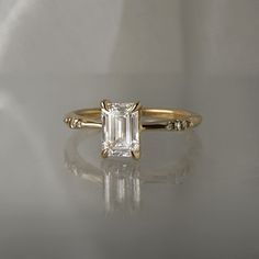 an engagement ring with a emerald cut diamond