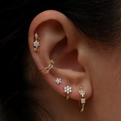 a close up of a person's ear with three piercings