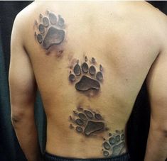 a man's back with an animal paw tattoo on it