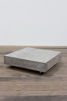 a concrete box sitting on top of a wooden floor