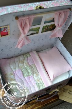 an open suitcase with pink bedding and pillows in it's side opening area