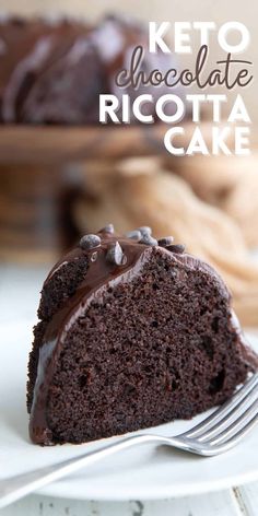 a slice of chocolate cake on a white plate with a fork in front of it