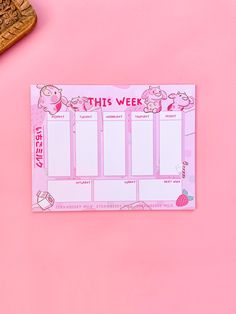 this week planner sticker on a pink background next to a wooden spoon and pen