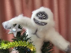 a white stuffed animal hanging from a christmas tree