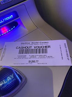 a ticket sitting on top of an airplane seat next to a remote control unit with the word cashout voucher printed on it