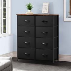 a black dresser with drawers in a blue room