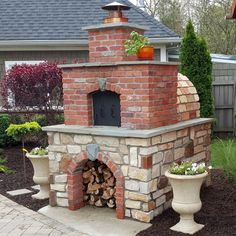 an outdoor brick pizza oven with potted plants