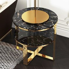 a black and gold table sitting on top of a wooden floor next to a chair