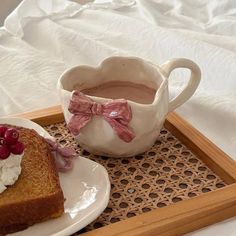 two pieces of toast with whipped cream and cranberries on a tray next to a cup of hot chocolate