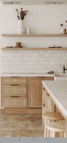 a kitchen with wooden cabinets and white tiled backsplash, counter tops and shelves