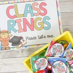 a yellow container filled with candy next to a sign that says class rings